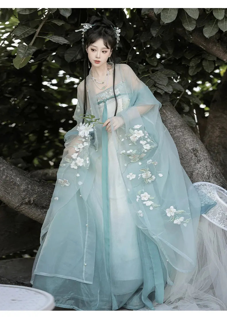 Woman ingreen Floral Traditional Chinese Tang style Hanfu Dress  with floral patterns standing outdoors.