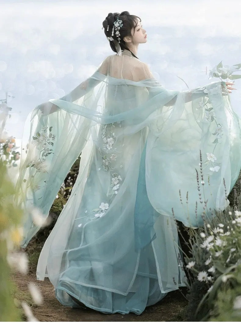 Woman in a green Floral Traditional Chinese Tang Dynasty Hanfu Dress standing in a natural setting with flowers.