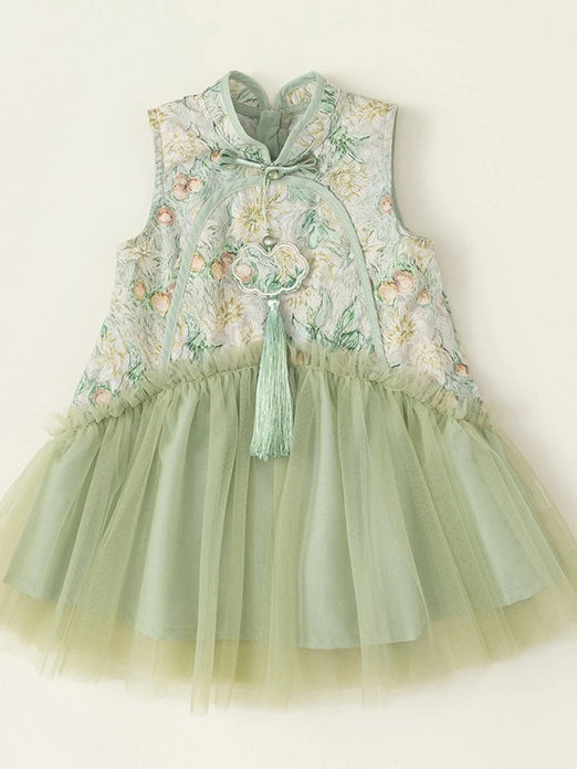 A sleeveless toddler dress with a light sage green Girls Traditional Chinese Floral Sleeveless Tulle Qipao with tulle skirt and a matching embroidered bodice. The bodice features a floral pattern in soft pink, yellow, and green on a pale background, with a traditional high collar, tie closure, and a decorative tassel.