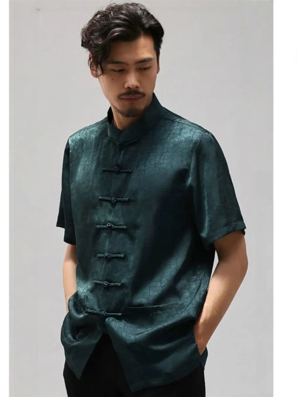 Man wearing a dark green traditional Men's Luxury Mulberry Silk Jacquard Short Sleeve Tang Shirt  against a plain background