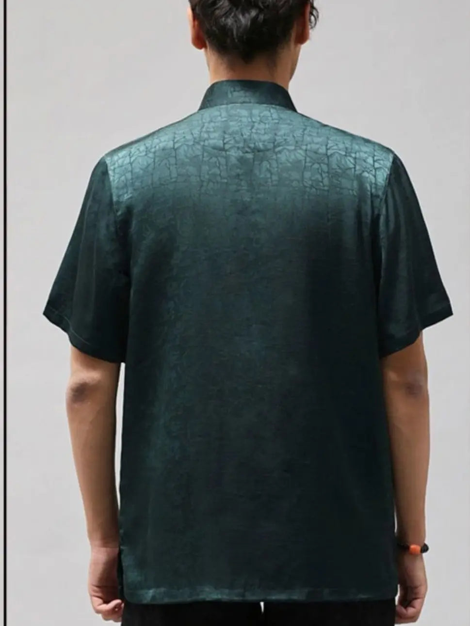 Person wearing a dark green patterned Men's Luxury Mulberry Silk Jacquard Short Sleeve Tang Shirt  against a plain background