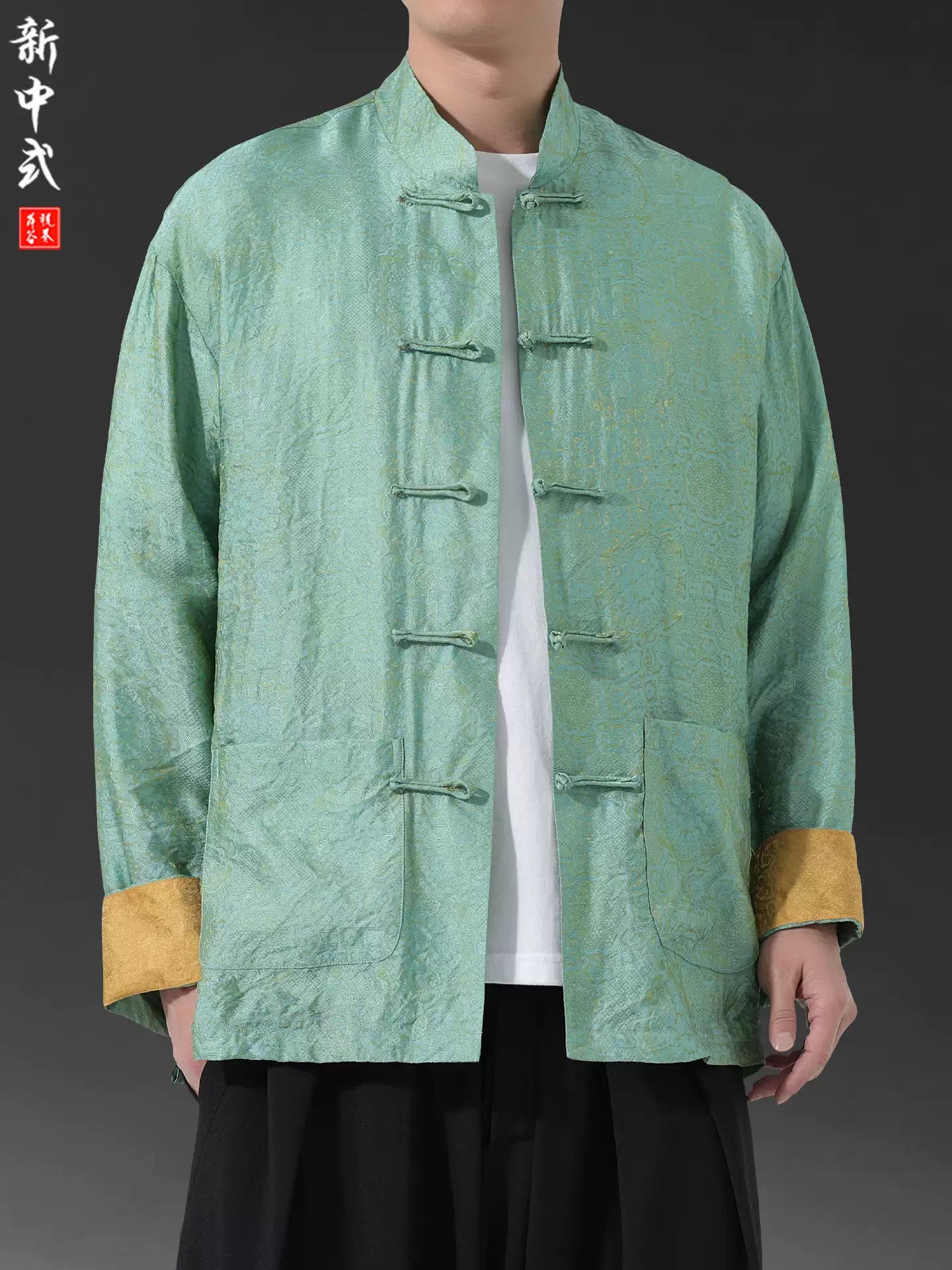 Green traditional Men's Oriental Jacquard Kung Fu Tang Shirt with gold cuffs on a gray background