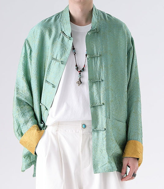 Person wearing a green textured Men's Oriental Jacquard Kung Fu Tang Shirt with yellow cuffs and a white shirt underneath on a light gray background.