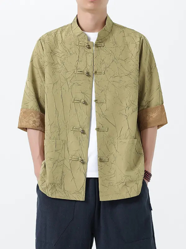 Person wearing a patterned green Men's Retro Crinkle Texture Half Sleeve Tang Suit Summer Shirt with short sleeves on a white background