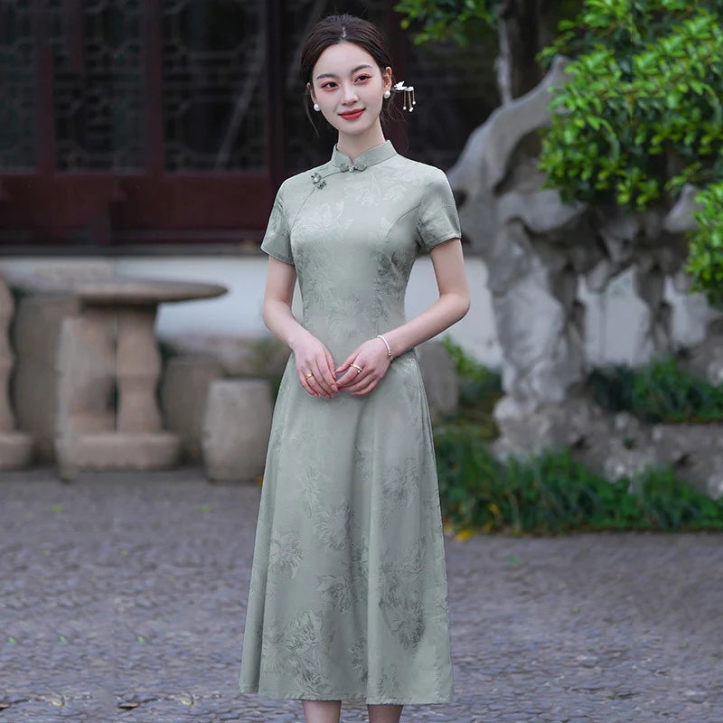 Woman wearing a green Modern Ao Dai Style Floral Jacquard A-Line Qipao dress standing in an outdoor setting with stone pavement and greenery.