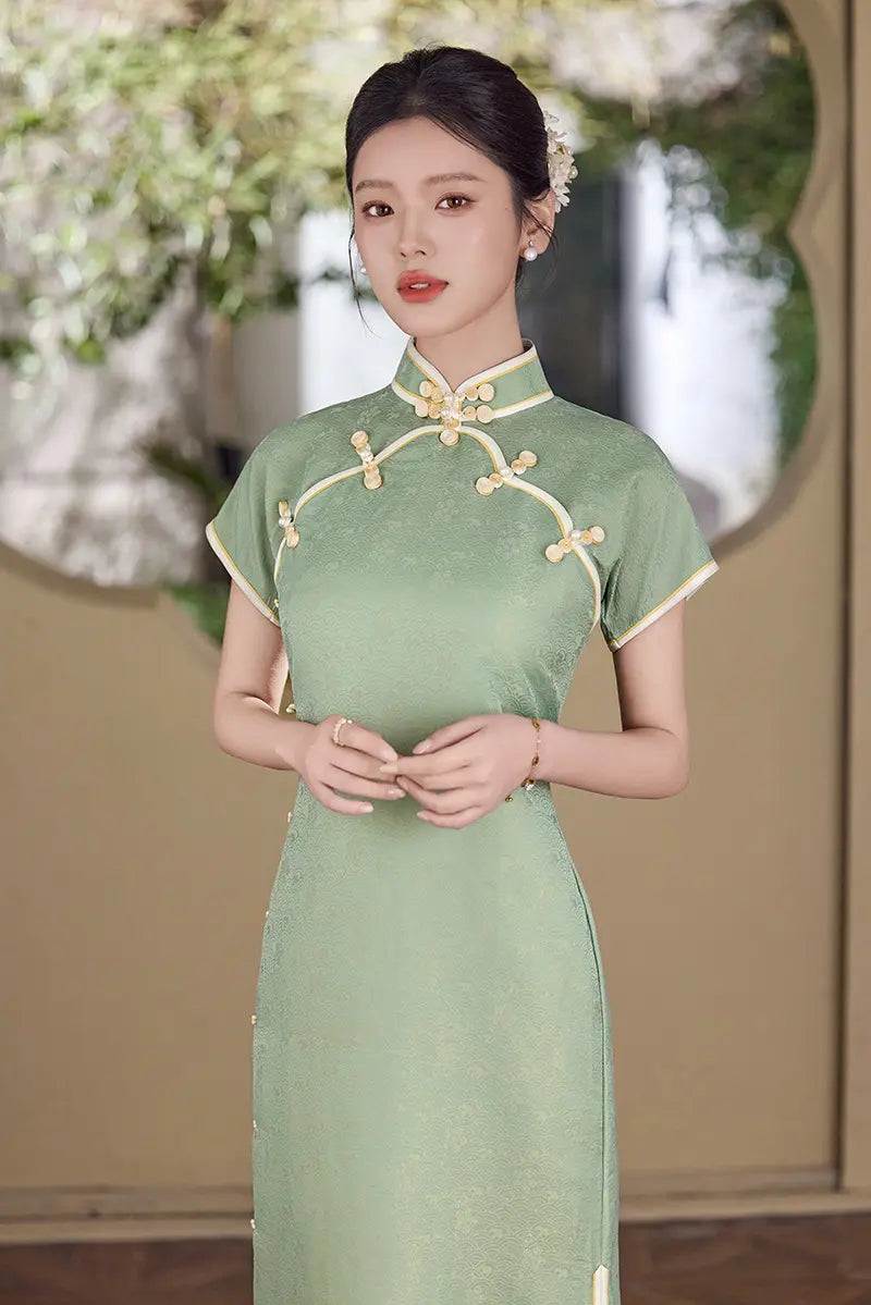 Woman wearing a  green traditional  Song Brocade Full-Opening  Qipao Dress  with white floral decorations in an outdoor setting.