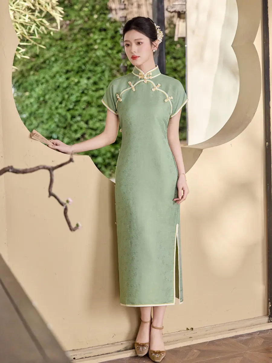 Woman in a  green traditional  Song Brocade Full-Opening  Qipao Dress standing in a decorative doorway.