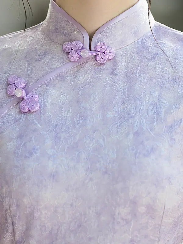 Close-up of a lavender Chinese cheongsam-style top with a tonal floral jacquard texture and matching fabric frog closures on the collar and chest.