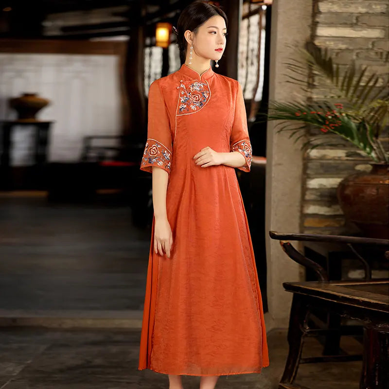 Woman wearing an orangeModern A Line Loose Cheongsam Qipao Dress with Sheer Sleeve  with intricate patterns in a rustic setting
