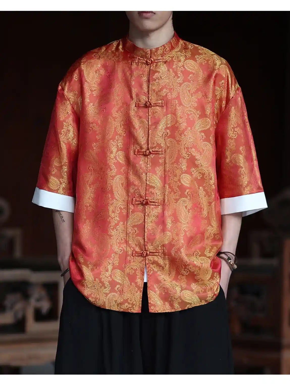 Person wearing a red and gold patterned Modern New Chinese Style Men's Half Sleeve Jacquard Tang Shirt  with a blurred background