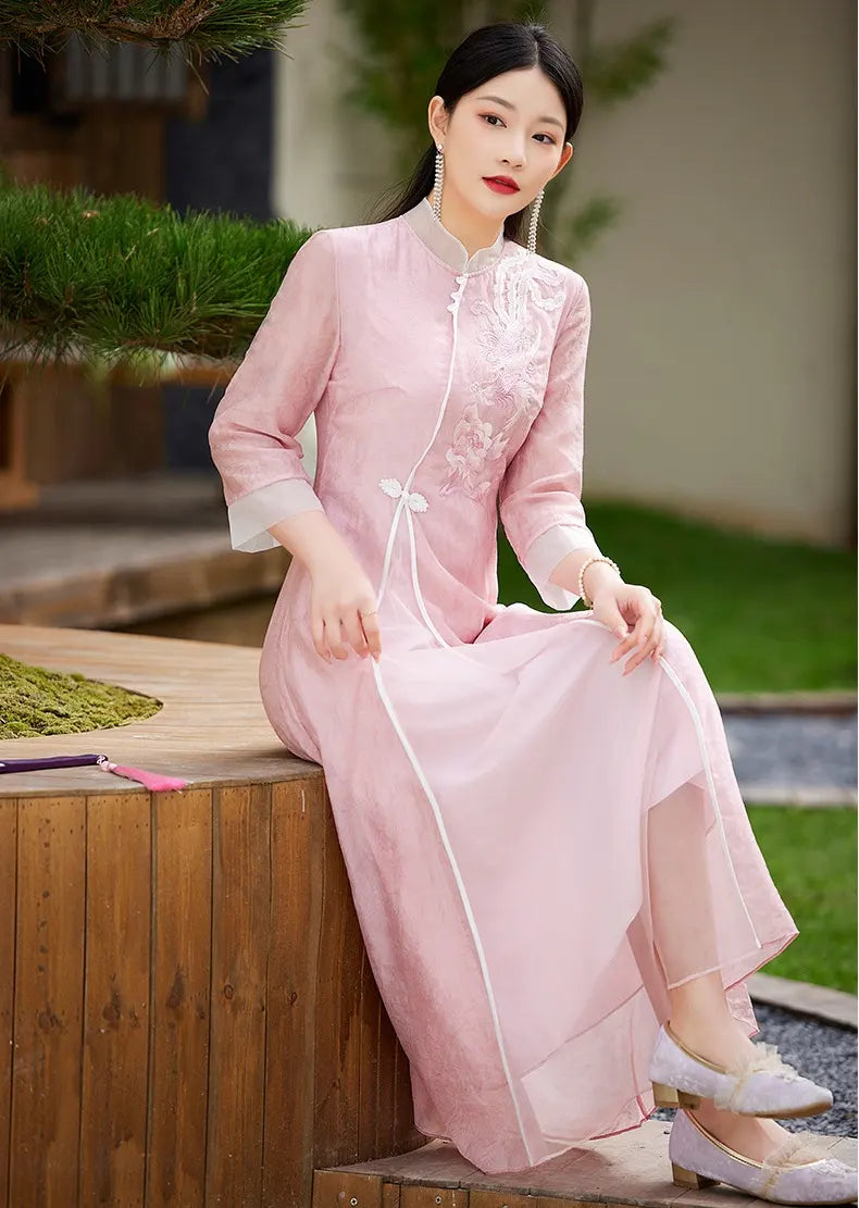 Woman in a Floral Embroidered Loose A line pink Cheongsam Qipao Dress traditional outfit sitting outdoors.