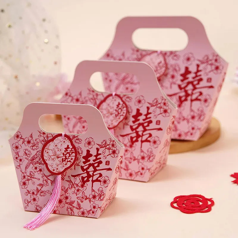 pink Floral Chinese Wedding Favor Boxes with Double Happiness Tassel with red Chinese characters and floral patterns on a light background