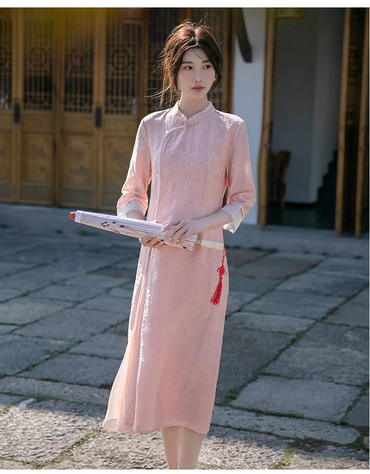 Woman in a traditional pinkLoose A Line Cheongsam Qipao Dress holding a scroll outdoors.