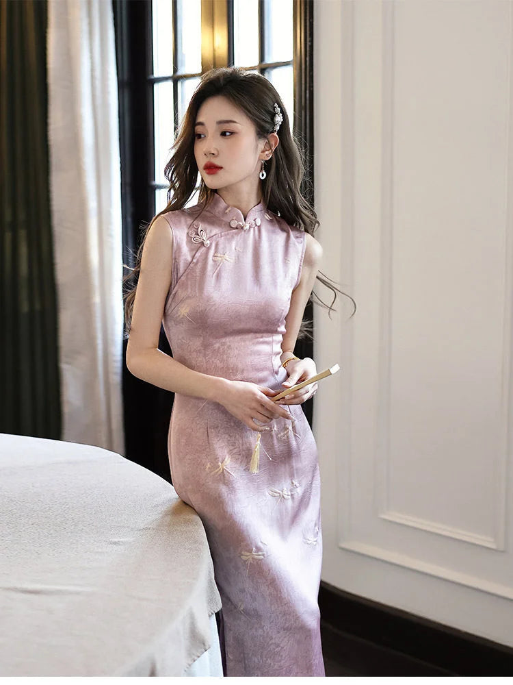 Woman in a pink traditional chinese Modern Minimalist  Sleeveless Qipao cheongsam With Dragonfly Print dress standing indoors with a neutral background