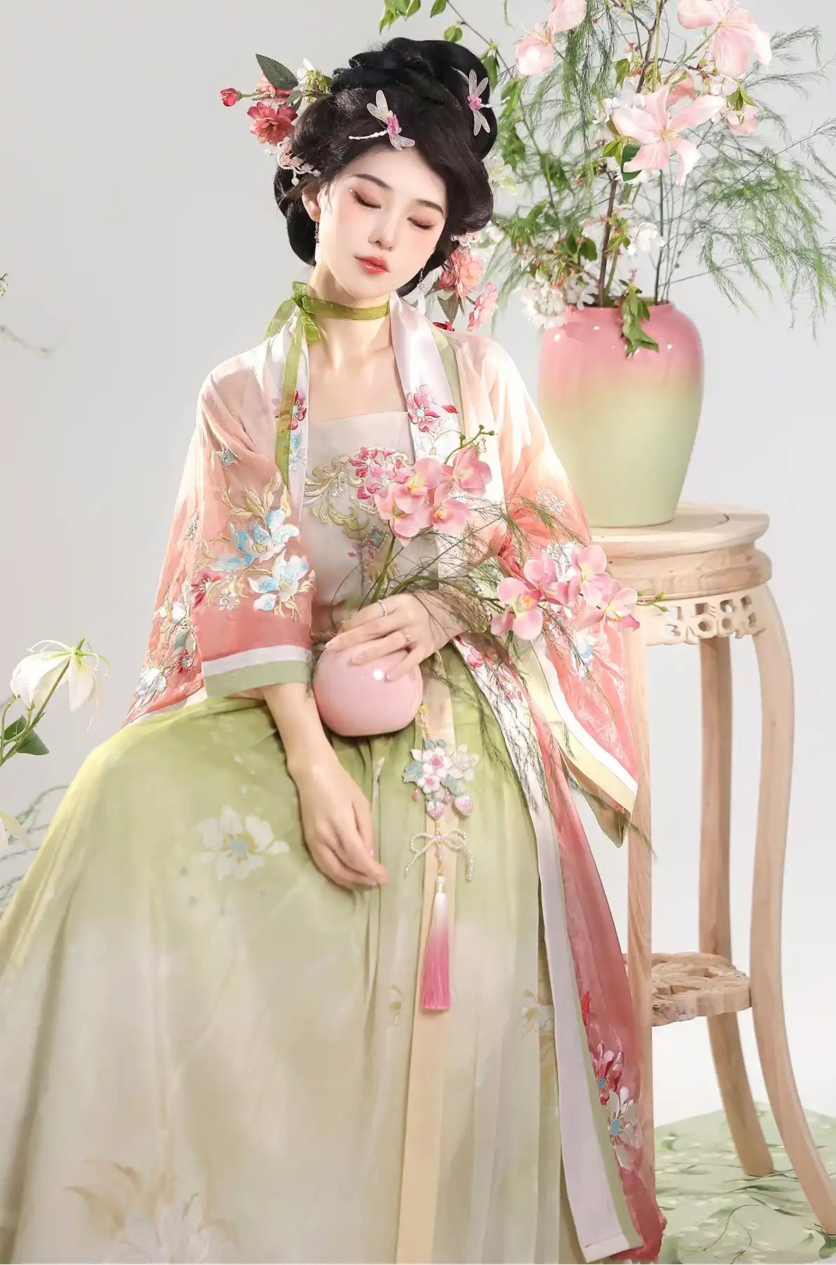 Person in pink Traditional Chinese Dress – Elegant Song Dynasty Hanfu Set  with floral decorations sitting on a stool.