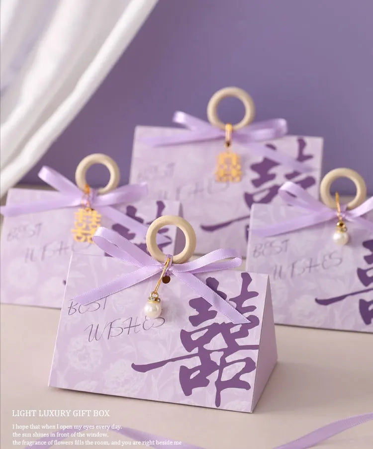Light purple Floral Triangular Shape Double Happiness Favor Boxes  with ribbons and decorative elements on a light background