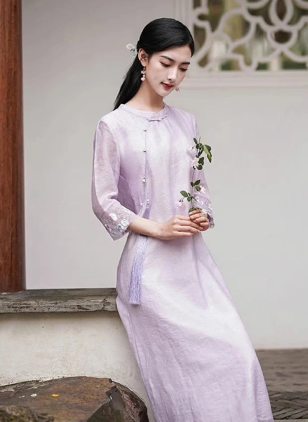 A chinese Woman in a light purple Loose A line Cheongsam Qipao Dress  holding a plant against a neutral background