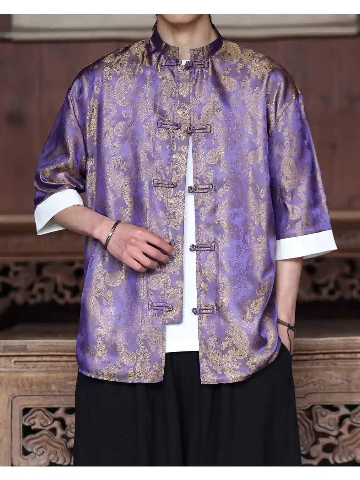 Person wearing a traditional purple and gold patterned Modern New Chinese Style Men's Half Sleeve Jacquard Tang Shirt  with white cuffs and collar.