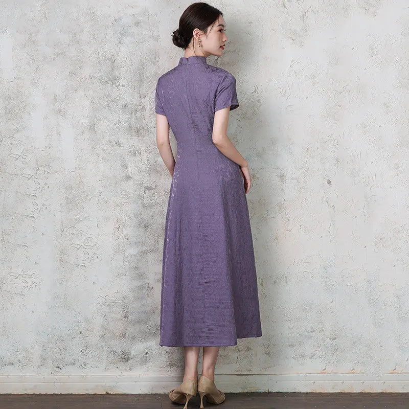 Woman wearing a purple  Short Sleeve Floral A Line Qipao cheongsam standing against a textured wall.