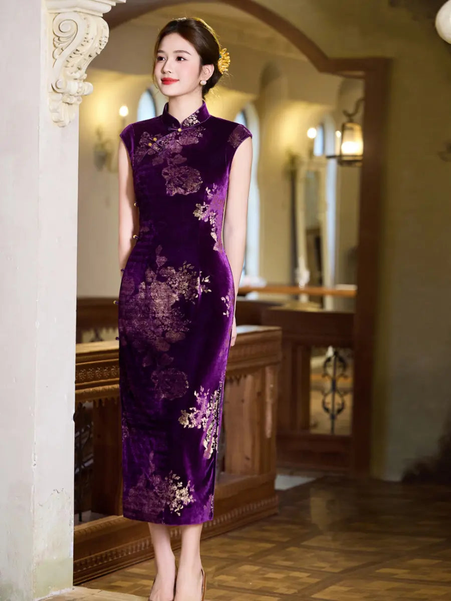 A woman wearing a sleeveless purple velvet cheongsam dress with gold floral embroidery, standing in a warm, traditional Chinese-style interior hallway.
