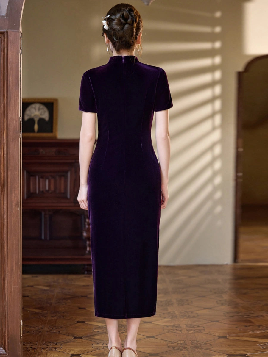 A woman viewed from behind wearing a dark purple velvet cheongsam-style midi dress in an elegant indoor setting with warm sunlight and shadows.