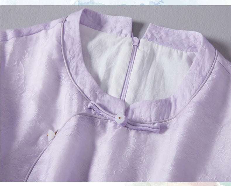 Close-up of a light purple garment with a button on a gray background