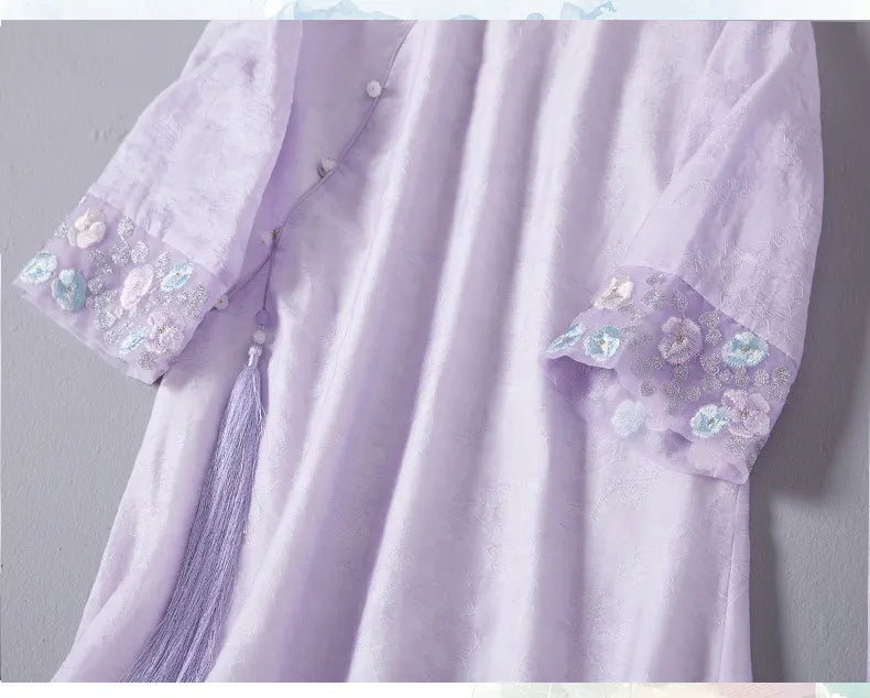 Light purple dress with floral embroidery on sleeves against a gray background