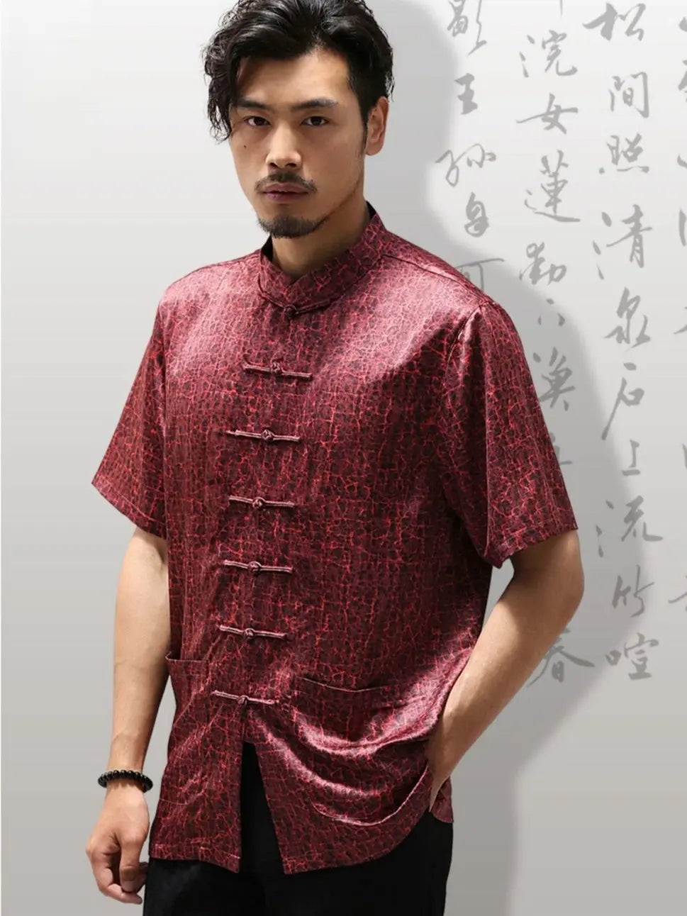 Man wearing a maroon traditional Chinese Men's Luxury Mulberry Silk Jacquard Short Sleeve Tang Shirt  against a light gray background with Chinese calligraphy.