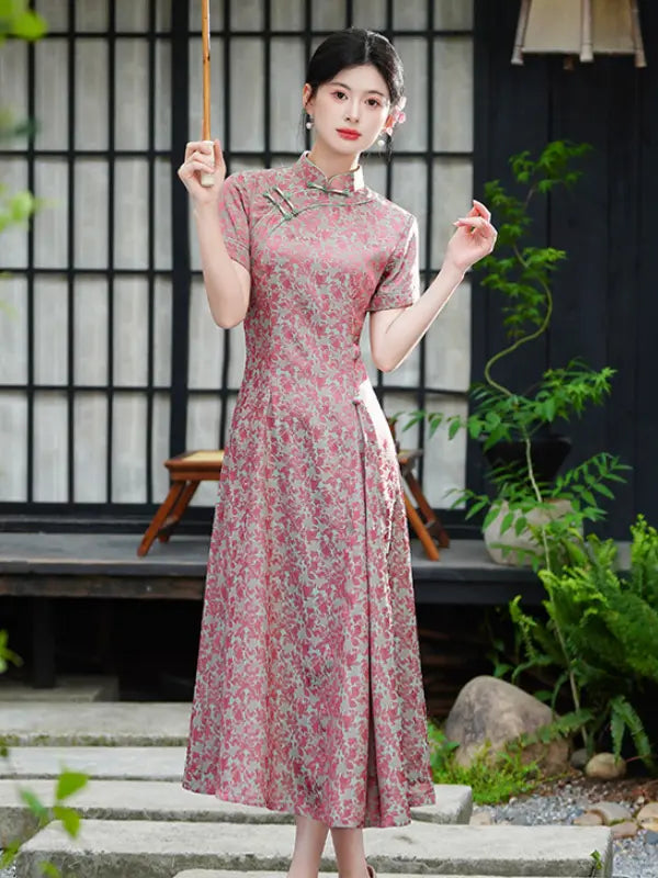 Woman in a pink Modern Floral Short Sleeve A-Line Qipao Dress  standing outdoors with plants and a traditional Japanese house in the background.