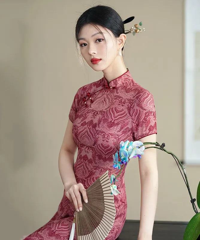 Woman in a red traditional Short Sleeves patterned  A-Line Qipao Dress holding a fan with a blurred background