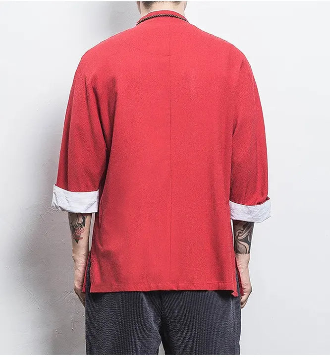 Person wearing a red Three-Quarter Sleeve Zen Heritage Linen-Blend Kong Fu Tang Shirt  with rolled-up sleeves against a plain background
