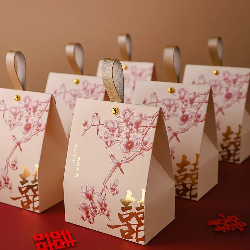 Decorative red and gold Double Happiness Chinese Wedding Favor Box  with Blossom & Bird desigin  with floral designs and gold accents on a red surface.