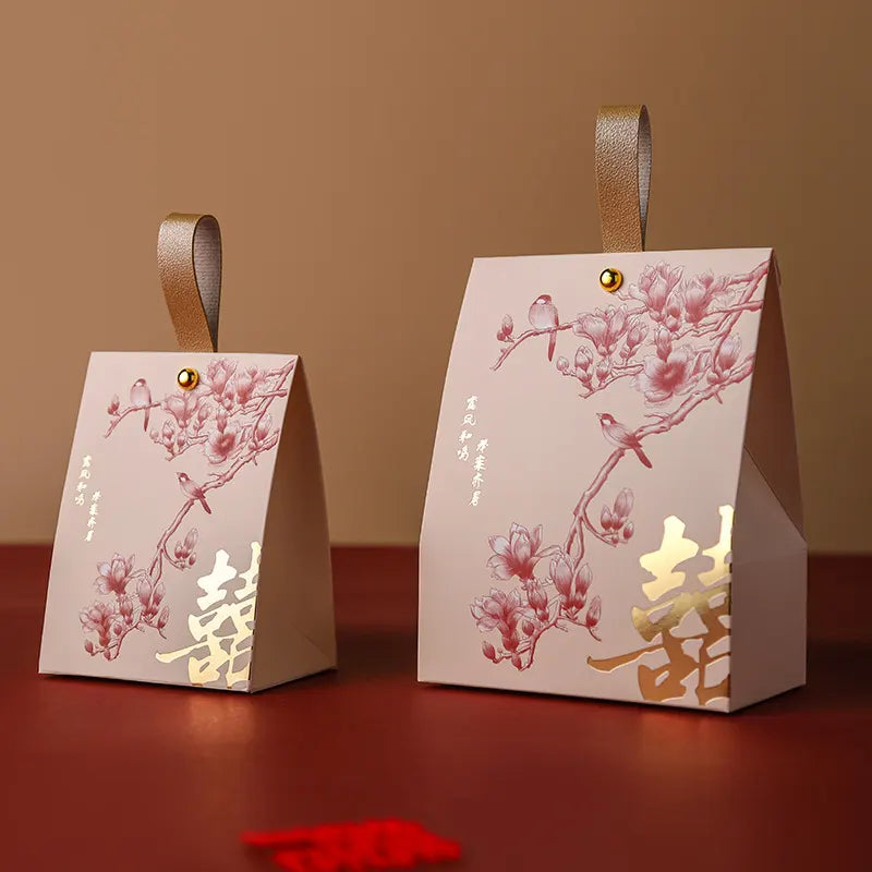 Two red and gold Double Happiness Wedding Favor Box  with Blossom & Bird design  on a red surface.