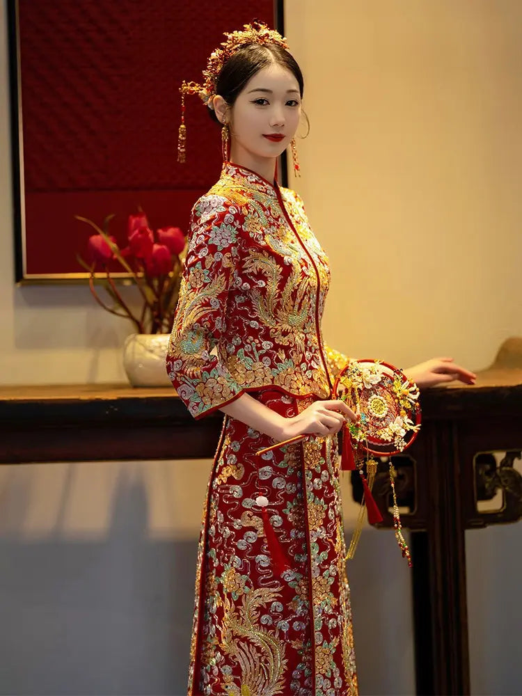 Bride wearing a traditional red Qun Kwa embroidered with golden phoenix and dragon motifs.