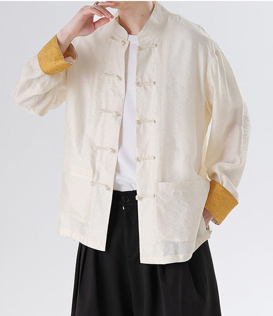 Person wearing a cream-colored Men's Oriental Jacquard Kung Fu Tang Shirt with yellow cuffs and a white shirt underneath on a light gray background