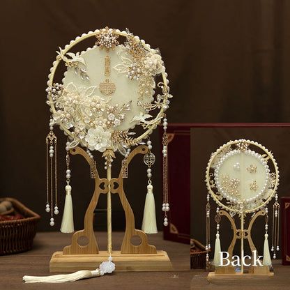 Traditional Ivory White and Golden Chinese Bridal Hand Fan adorned with ornate white lace floral patterns, gold details, delicate pearl accents and cascading tassel