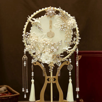 Traditional Ivory White and Golden Chinese Bridal Hand Fan adorned with ornate white lace floral patterns, gold details, delicate pearl accents and cascading tassels