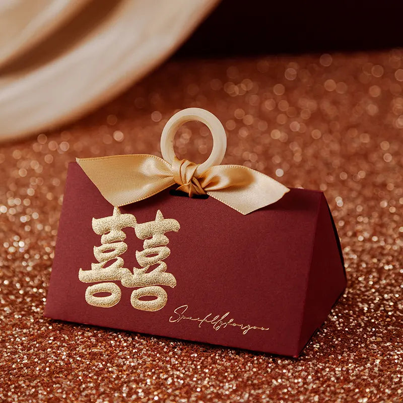 Red Luxury Gold Foil Double Happiness Favor Boxes gift box with gold ribbon and Chinese characters on a glittery surface