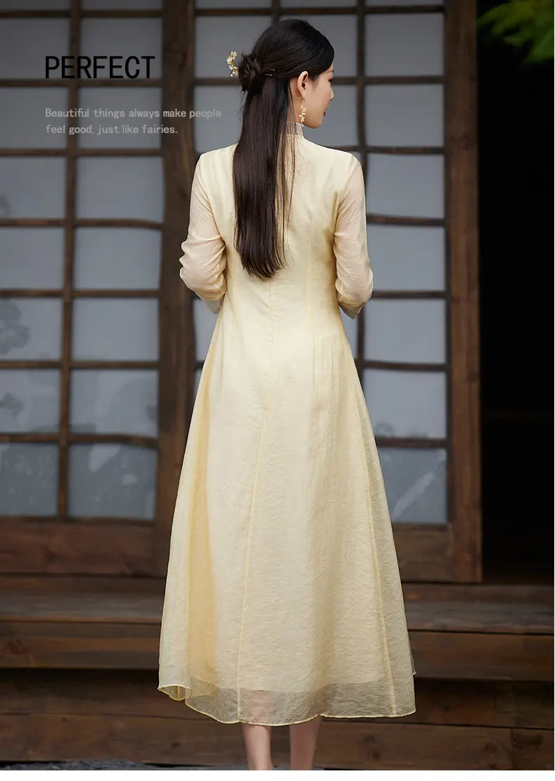 Woman wearing a Floral Embroidered Loose A line yellow Cheongsam Qipao Dress standing in front of a wooden door.